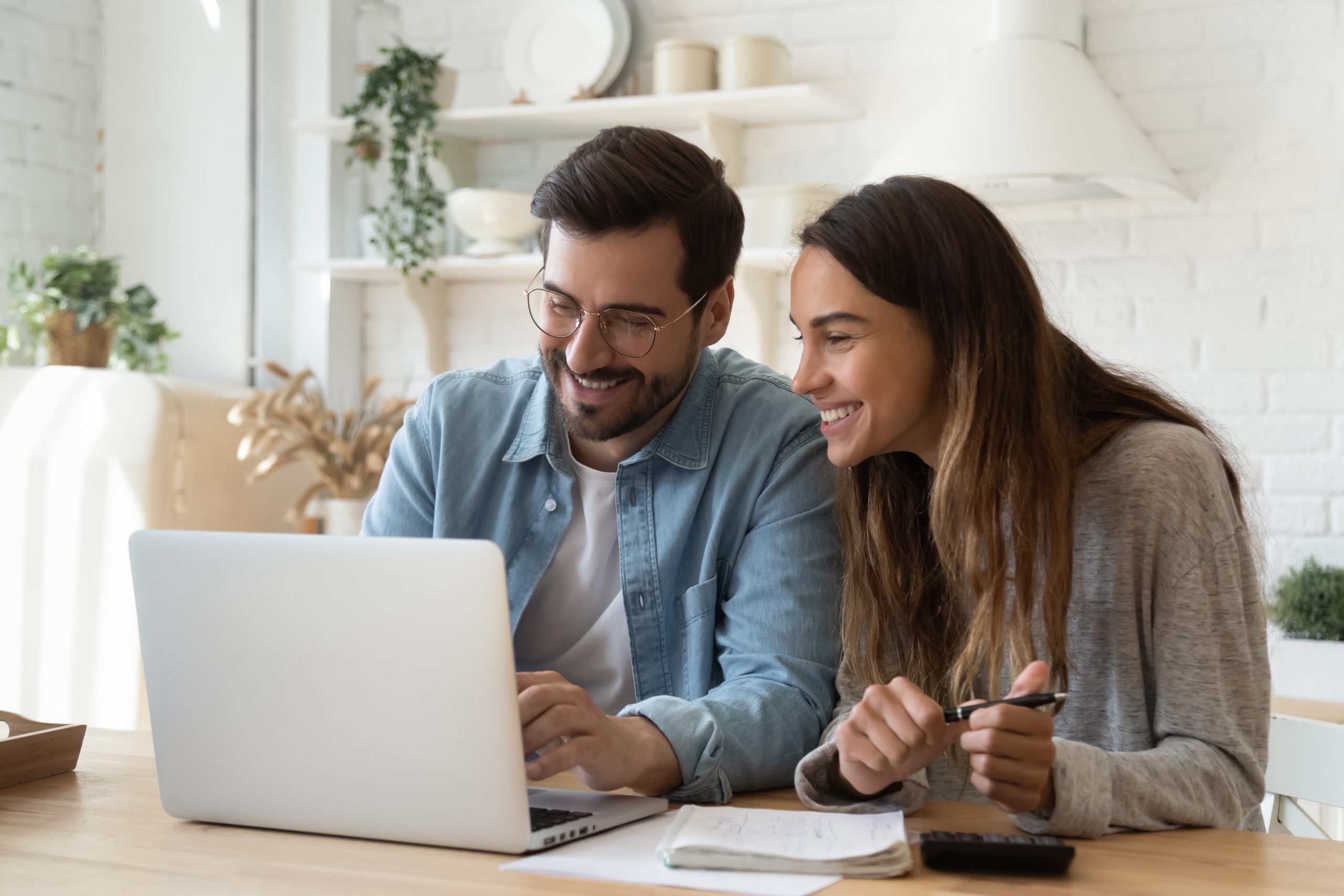 Happy young couple paying bills online in computer app ...